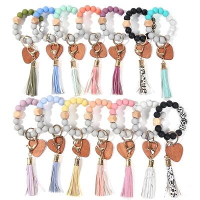 China Eco-Friendly Customized Key Chain Wooden Monogram Tassel Silicone Bead Bangle Bracelet Elastic Macrame Keychains for sale