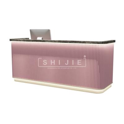 China SHIJIE Hot Selling Expandable Customize Front Reception Desk Counter LED Pink Executive Salon Beauty Salon for sale