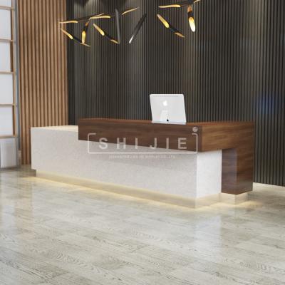 China SHIJIE Extendable Company Furniture White Commercial Reception Desk Design Customize Hotel Reception L Shaped Front Desk for sale