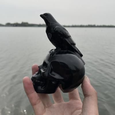 China Natural Africa Crystal Skulls Hand Carved Black Crystal Obsidian Skulls With Raven for sale