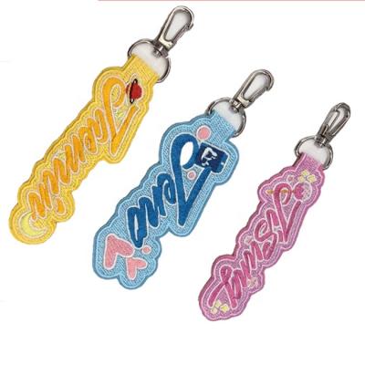 China Custom Fabric Keychain Embossed Embroidery Luggage Apparel Fabric Hang Tag Embroidered Keychain for sale