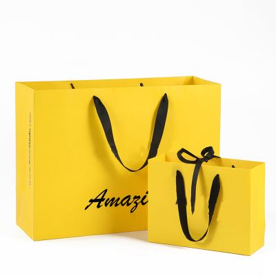 China Recyclable Wholesale logo printed luxury merchandise retail tote cardboard bag for packaging paper shopping bags for clothes/clothing for sale