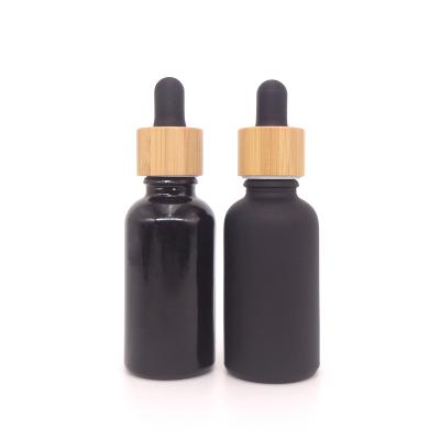 China Personal Care 30ml Glaze / Frosted Black Glass Dropper Bottle With Bamboo Lid for sale