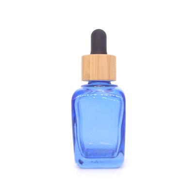 China Wholesale Personal Care 1oz Blue Painted Square Glass Bottle With Bamboo Dropper Cap With Graduation for sale