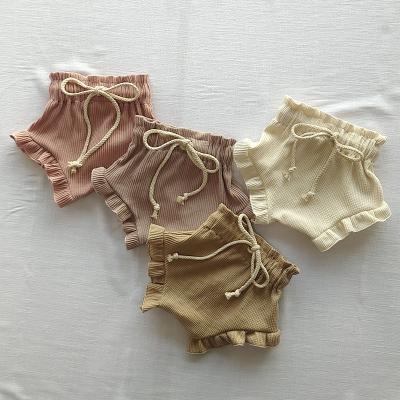 China Color Fade Proof New Baby Casual Shorts Summer Baby Clothing Fashion Drawstring Design Waffle Solid Color Elastic Ruffle Bloomers for sale