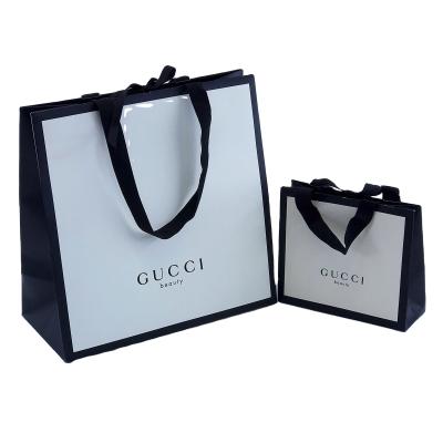 China Custom Logo Luxury Fashion White Paper Bag Recyclable With Line Texture Handle Cotton Rope For Cosmetics Clothing Packaging Paper Bag for sale