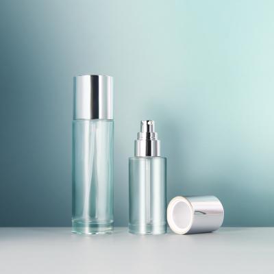 China 50ml 100ml Silver Cosmetic Transparent Round Pump Oil Cream Lotion Glass Bottle Pump Cosmetic Packaging for sale