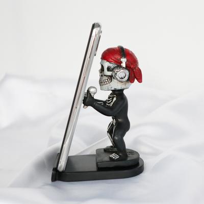 China Custom Creative Europe Resin Skull Mobile Phone Holder For Office Home Office Desk Decor for sale