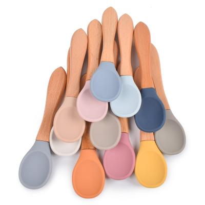 China Hot Selling BPA Free Toddler Safe Weaning Soft Feeding Spoons 100% Silicone Tips Infant Baby Spoons With Wooden Handle for sale