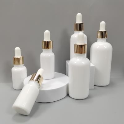 China Cosmetic cosmetic bottle for 50ml pearl glass bottle white essential oil bottle with gold aluminum cap for sale