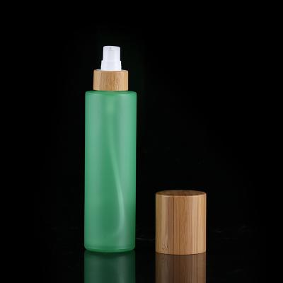 China 30ml 50ml 100ml 120ml cosmetic green frosted cosmetic glass bamboo lotion bottles with custom screen printing for sale