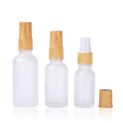 China Essential Oil Mist Spray Luxury Cosmetic Glass Perfume Bottle 30ml 50ml 100ml Frosted Glass Bottle With Wooden Sprayer for sale