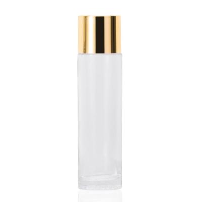 China Hot sale 120ml personal care toner bottle transparent glass bottle with shiny gold cover for essential/toner package for sale