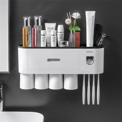 China 2021 New Bathroom Accessories Viable Plastic Magnetic Automatic Toothpaste Dispenser Toothbrush Holder With Four Washing Cups for sale