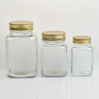 China New Home Luxury Square Jars Food Grade Glass Coffee Honey Glass Bottles With Gold Aluminum Lids for sale