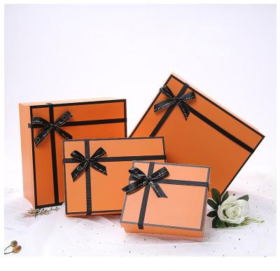 China Modern Luxury Custom Orange Paper Birthday Valentine Day Gift Boxes Cardboard Gift Packaging Box Christmas With Black Hot Stamping Bowknot for sale