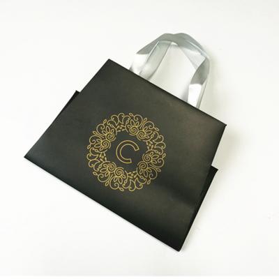 China Luxury Golden Logo Silkscreen Black Coated Paper Packaging Bag With Ribbon Handle for sale