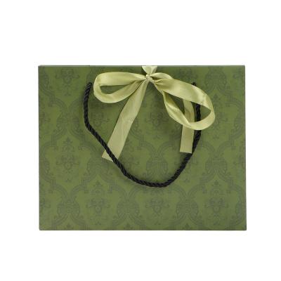 China Recycled Materials Custom Logo Christmas Tree Shopping Green Paper Bags Orange Gift Bags With Ribbon Bow Closure for sale