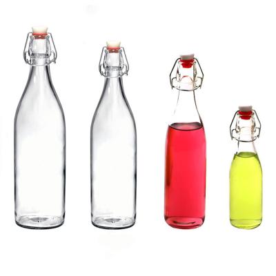 China Wholesale Price Beverage Round Tea Bottle 500ml Beverage Drinking Bottle Glass With Swing Top Cap for sale