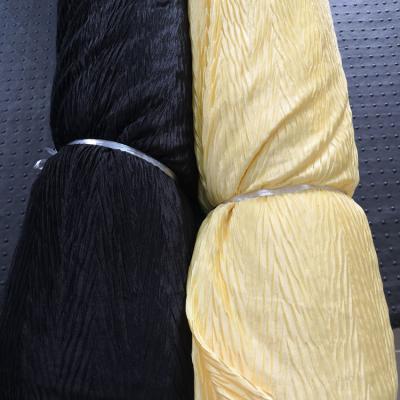 China Hot sale Shrink-resistant 100% polyester shinny stock FDY knitted pleated fabric for clothing for sale