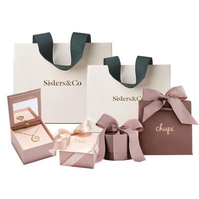 China Recyclable wholesale custom printed small ribbon jewelry boutique shopping gift glossy laminated luxury paper bag with logo for sale