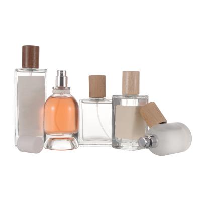 China New 30ml 50ml 100ml Cosmetic Promotional Refillable Clear Frosted Glass Perfume Bottles With Wooden Caps for sale