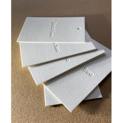 China Custom White Recyled Debossed Clothes Brand Hang Tags For Clothing Personalized Swing Price Tag for sale