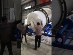 A rotational molding machine for producing water tanks.