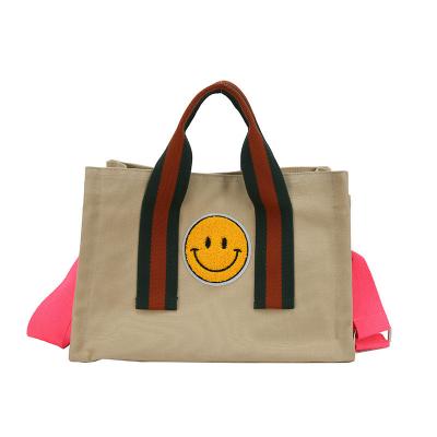 China Folding Carrying Women Bag Large Capacity Canvas Bag Leisure Cute Smiling Soft Shoulder Bag Cross-Body Bag for sale