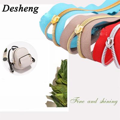 China Eco-friendly High Quality Aluminum Zipper Teeth Long Chain Shiny Gold Zipper Coil for sale