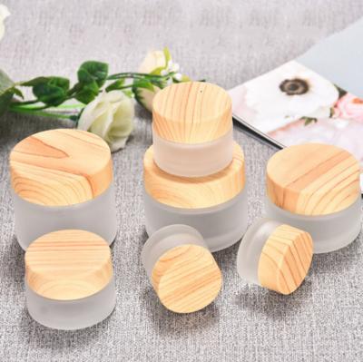 China 5/10/15/20/30/50g Personal Care Cream Jar Empty Frosted Glass Cosmetic Packaging Containers With Wood Grain Cover for sale