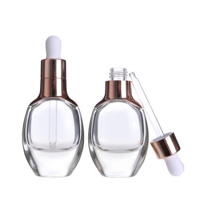 China Empty Cosmetics 30ml Essential Oil Perfume Bottles Clear Pole Flattened Luxury Cosmetic Dropper Bottles With Rose Gold Dropper for sale