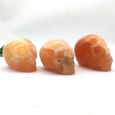 China Europe wholesale natural hand carved orange crystal polished calcite skull quartz skull for sale or decoration for sale