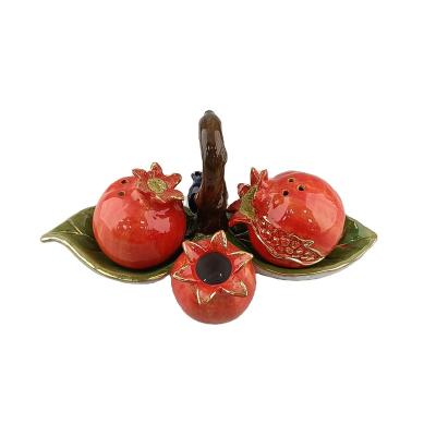 China HS Sustainable Pomegranate Series Luxury Golden Pomegranate Shaped Ceramic Salt and Pepper Pots with Leaf Base for sale