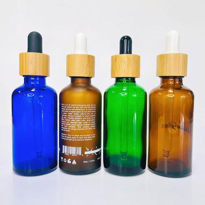 China Personal Care Luxury 30ml 50ml 100ml Frosted Amber Green Blue Glass Serum Essential Oil Dropper Bottle With Wooden Cap Bamboo Lid for sale