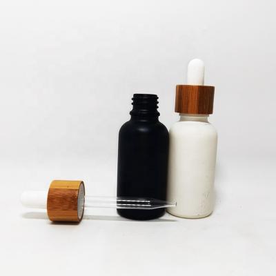 China 5ml cosmetic 10ml 15ml 20ml 30ml frosted matte black glass vial with bamboo lid and dropper pipette bottle for essential oil for sale