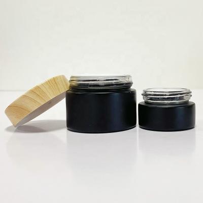 China 5g cosmetic 15g 30g 50g 100g frosted amber black cosmetic glass jar with bamboo screw on lid for sale