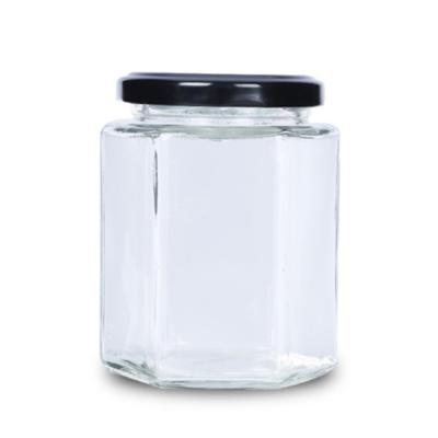 China 380ml 500g stock hexagon glass jar container for jam honey with black metal lid for sale