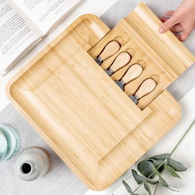 China Stocked bamboo cheese board set large wooden Charcuterie board set with narrow, flat knives, cheese fork for sale