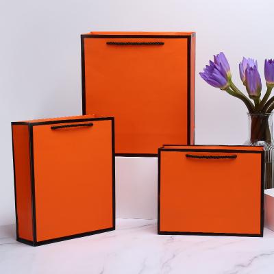 China Recyclable Gift Kraft Paper Handle Luxury Orange Shopping Paper Bag With Your Own Logo for sale