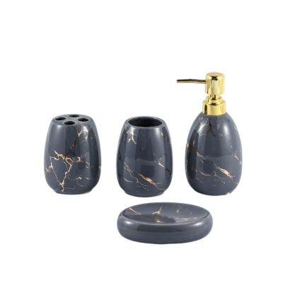 China Sustainable Modern Gold Ribbed Black Ceramic Bath Lotion Dispenser Glazed Soap Dish 4Pcs Bathroom Accessory Set for sale