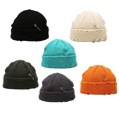 China CaiNan COMMON streetwear fashion winter hat custom acrylic knit skullcap with safety pins tore distressed skullcap for sale