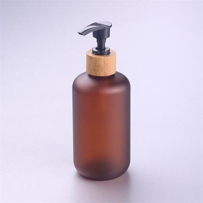 China Personal Care 250ml Pet Amber Frosted Bottle With Pump Bamboo Lotion Shampoo Bottle for sale