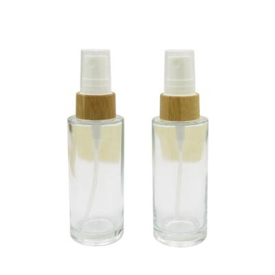 China 30ML Cosmetic Glass Bottle With Bamboo Treatment Pump 50ml Frosted Bamboo Spray Glass Cap for sale