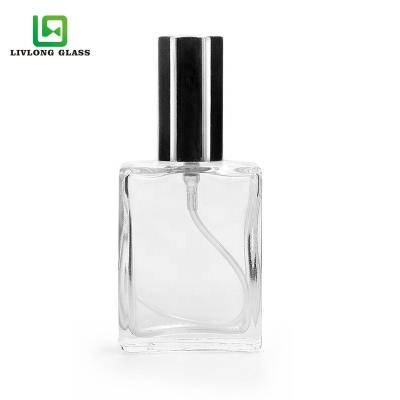 China Hot Selling Personal Care 15ml Drum Shape Flat Transparent Perfume Cosmetic Essential Oil Packing Glass Bottle With Spray for sale