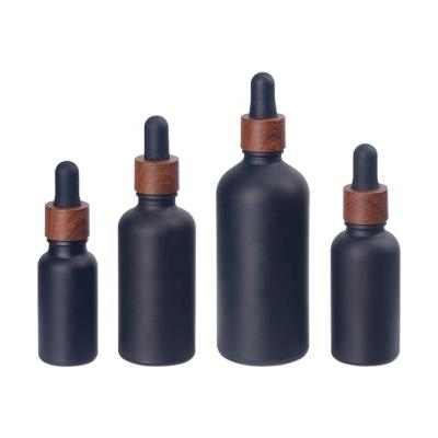 China 5ml 20ml 25ml 10ml 30ml 50ml 100ml Matte Black Essential Oil Glass Bottle Cosmetic Maker With Bamboo Dropper Cap for sale