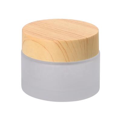 China Grain Personal Care Cosmetic Wooden Cosmetic Jar 50ml Frosted Glass Jar With Wooden Lid for sale