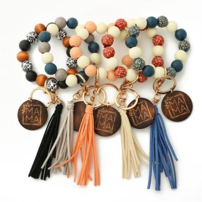 China Light wood and bracelet silicone beaded key chain for women metal key chains with leather tassels custom logo for sale