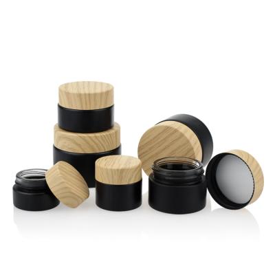 China Cosmetic Skin Care Cream Packaging Bottles Container Set Small Round Glass Jar With Bamboo Color Lid for sale