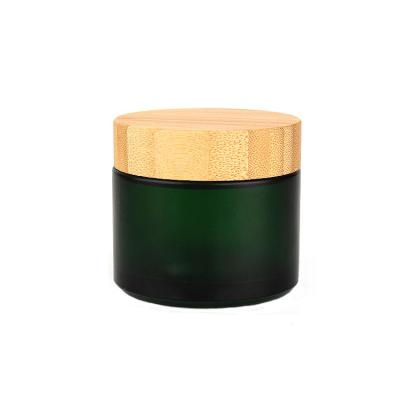 China 3oz Green Color Cosmetic High End Customized Glass Cream Jar With Bamboo Lid for sale